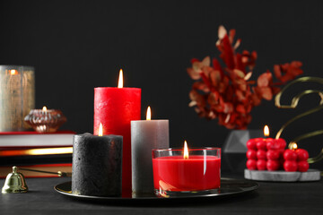 Beautiful burning candles and decor on black table