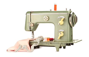 Sewing machine with pink fabric, measuring tape and spools of threads isolated on white