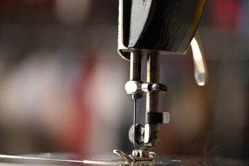 Sewing machine with thread on blurred background, macro view
