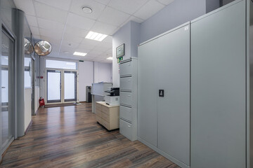 Lobby of a modern office with doors. Modern office interior with storage units and workstations in a bright environment during daylight hours