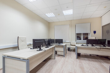 An open space of a modern office with light furniture and ergonomic chairs..