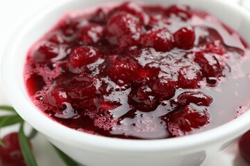 Tasty cranberry sauce in bowl on table, closeup