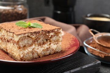 Delicious tiramisu with mint on table, closeup