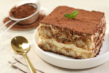 Delicious tiramisu with mint on light table, closeup