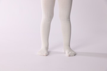 Child wearing tights on white background, closeup