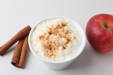 Delicious rice pudding with apple and cinnamon on light background, closeup