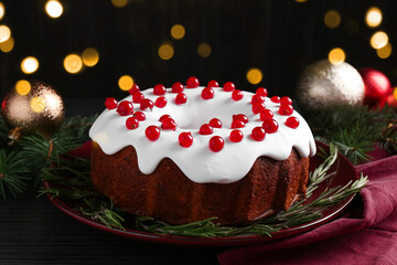 Tasty Christmas cake with red currants and rosemary on black wooden table, closeup