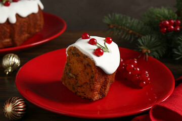 Piece of traditional classic Christmas cake and decor on wooden table, closeup
