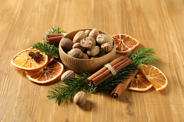 Fototapeta premium Different spices, dried orange slices and fir tree branches on wooden table. Christmas season