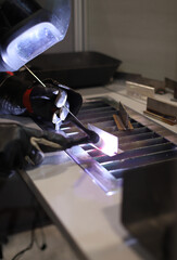 trabajador experto soldando una pieza de metal por inducción