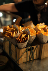 patatas fritas en cucuruchos de papel dentro de una caja de madera