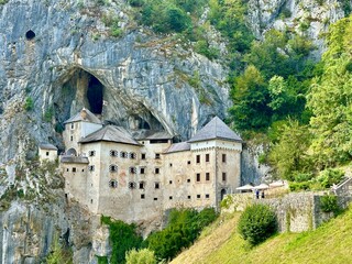 The photo depicts a picturesque rural landscape featuring a historic medieval castle.