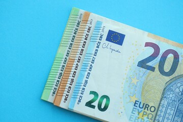 Big amount of one hundred, twenty and fifty euro money bills on blue background