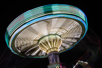 Title: Whirlwind of Lights: A Spinning Amusement Park Ride at Night