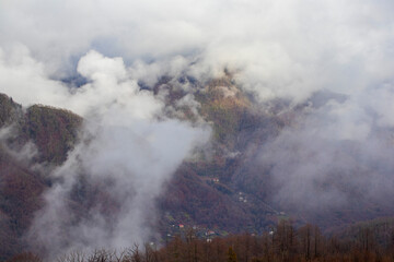 A majestic mountain completely covered in clouds on a very cloudy day