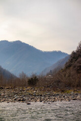A river flows through a valley with mountains in the background