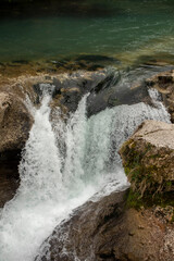 Experience the Serene Waterfall as it Cascades Beautifully Over Rocky and Rugged Terrain