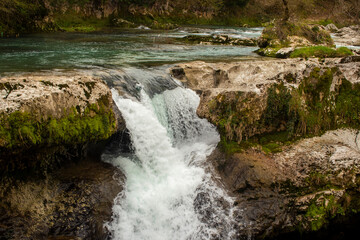 Experience the Serene Waterfall as it Cascades Beautifully Over Rocky and Rugged Terrain