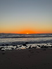 Beautiful and breathtaking sunset on a California beach at golden hour with ocean waves