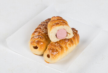 Hot sausages in a bun, with sesame seeds. On paper