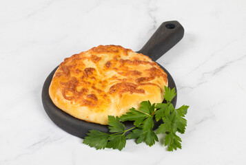 Georgian Cheese pie. Khachapuri. With parslety. On a wooden board. Rustic style. Close up