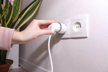 Woman plugging cable into smart plug