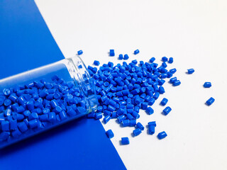 Blue masterbatch granules with glass tube on white and blue background,color pigment carrier...