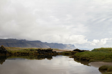 A dramatic Icelandic fjord with a mountain on the opposite side, surrounded by thick clouds