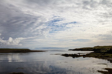 The calm sea in Iceland reflecting the clouds that seamlessly merge with the sky