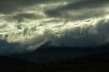 Icelandic mountains are under a dark, stormy sky
