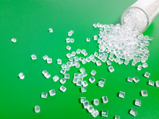 Polycarbonate plastic granules on green background, virgin polymer in plastic industry, perfect for...