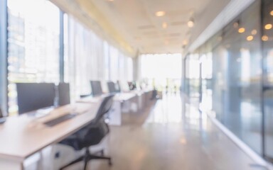 An empty, light-filled corridor in a modern office building with working tables