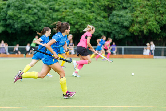 Action-packed field hockey match with players in colorful uniforms competing