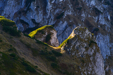 Sun shining bright at rocky area covered with moss and grass. Perfect hiking destination