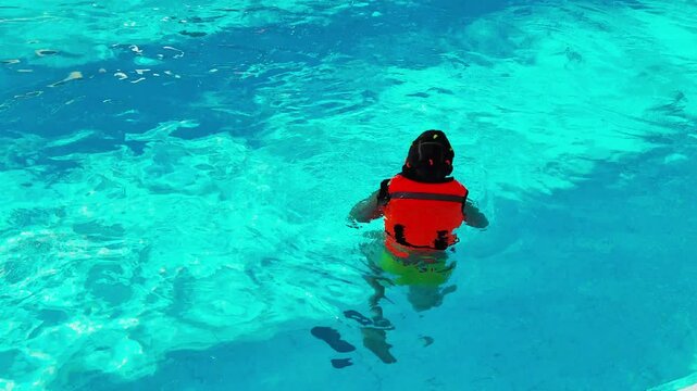 Girl in life jacket enjoying swimming pool adventure