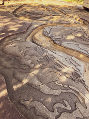 Topographical Map textured sculpture carved into the cement on a sunny summer day