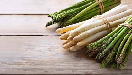 A close-up of green and white asparagus bundles tied with twine, resting on a rustic wooden surface, showcasing fresh and organic produce. Ideal for concepts of healthy eating and farm-to-table.