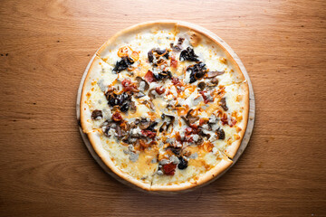 Mushroom and Onion Pizza served on wooden board isolated on table background top view of italian cousin