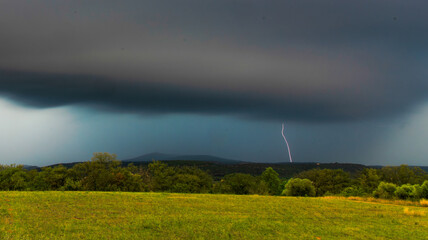 Eclair lumineux vertical sous le ciel noir de nuages