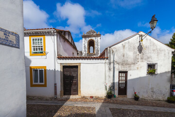 A historic monastery with a cloistered courtyard, surrounded by red-tiled roofs and lush greenery