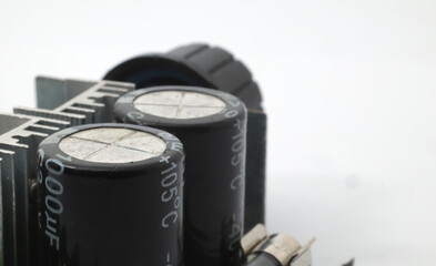 2 capacitors with a maximum usage of 105 degrees Celsius with other components on a white background. Electronic components that function to store electrical charges for a certain period of time.