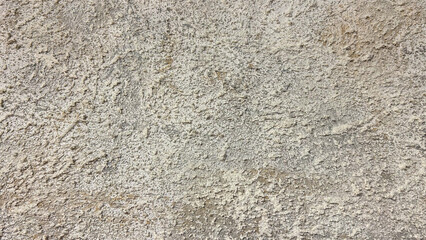 Rough textured beige wall close-up with natural uneven patterns, ideal for use as a background in architectural, interior design, or construction-related projects, emphasizing rustic and earthy aesthe