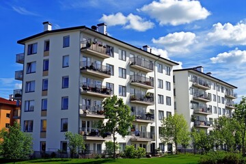 Sleek White Residential Complex Under a Clear Blue Sky with Lush Greenery