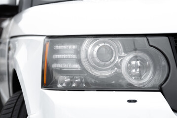 Fototapeta premium white car headlight, close up view, car dealing and manufacturing, cropped car image