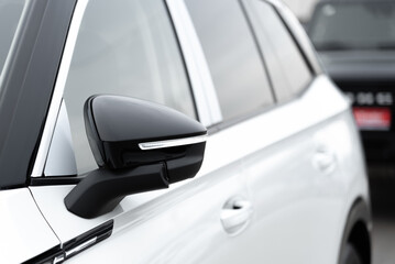 white car side view with rear view mirror, car dealing and manufacturing, cropped car image, selective focus