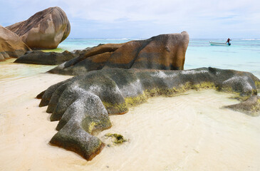 Granite rocks and fisherman of Anse source d'argent in La Digue, Seychelles