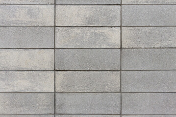Straight on view of a wall made of grey concrete block