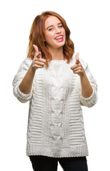 Young beautiful woman over isolated background wearing winter sweater pointing fingers to camera with happy and funny face. Good energy and vibes.