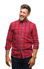 Fototapeta premium Young handsome man over isolated background winking looking at the camera with sexy expression, cheerful and happy face.