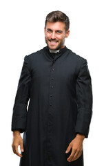 Fototapeta premium Young catholic christian priest man over isolated background looking away to side with smile on face, natural expression. Laughing confident.